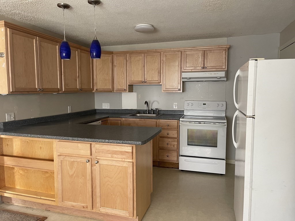 5 Turnpike Road, Unit 229 Townsend, MA 01469 - Photo 4 of 13 a kitchen with a white cabinets and white appliances