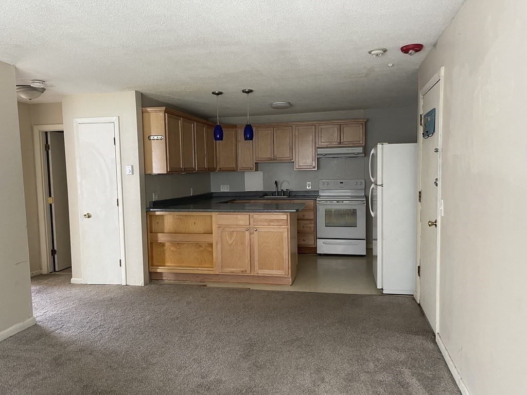 5 Turnpike Road, Unit 229 Townsend, MA 01469 - Photo 5 of 13 a kitchen with stainless steel appliances granite countertop a refrigerator and a sink