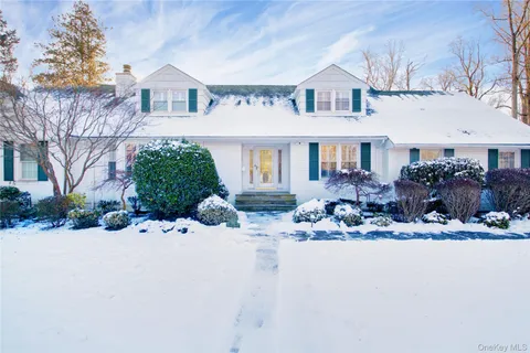 a view of a house with a yard covered in snow