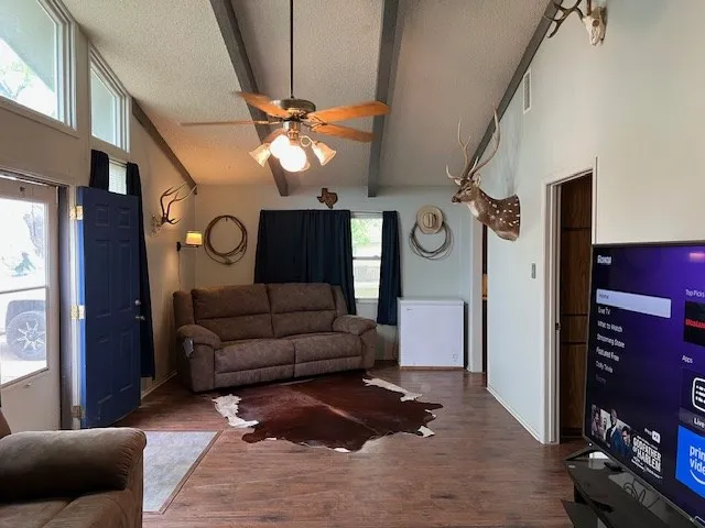 a living room with furniture a ceiling fan and a window