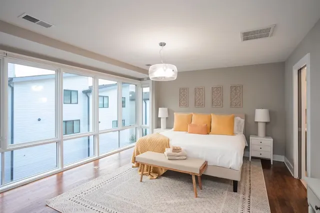 a spacious bedroom with a bed and a chandelier