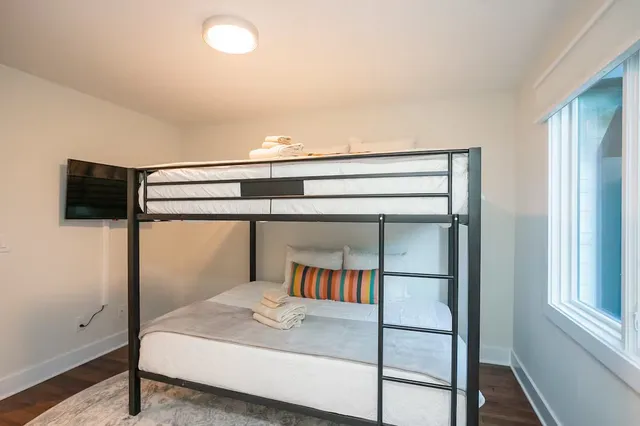 a bedroom with a bed and a flat tv screen on a dresser
