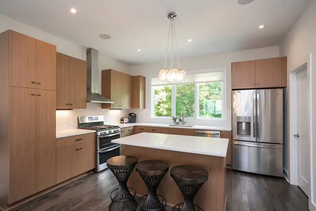 a kitchen with sink a refrigerator and wooden floor