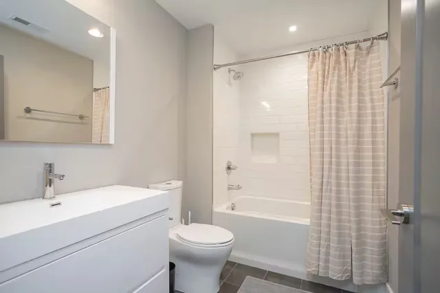 a bathroom with a shower toilet and sink