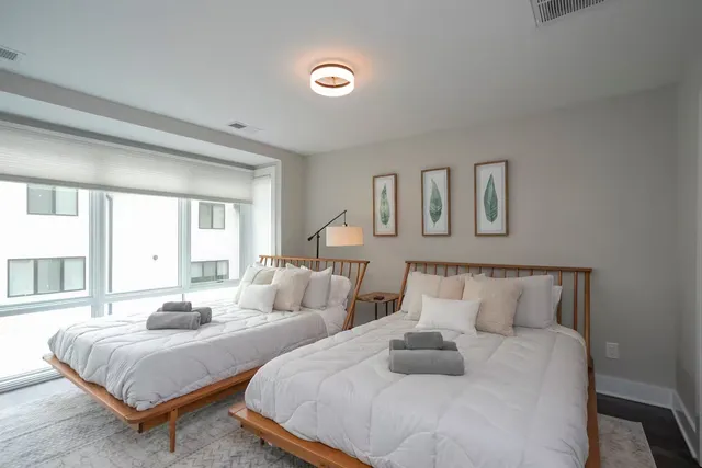 a bedroom with two beds and a large window