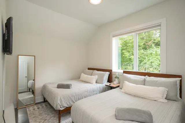 a bedroom with two beds and a large window