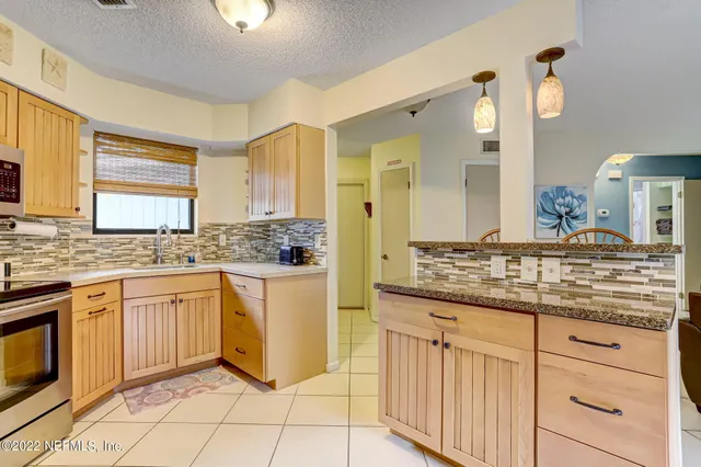 a kitchen with granite countertop white cabinets and white appliances