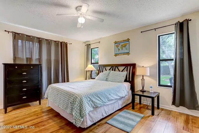 a bedroom with a bed a dresser and a window