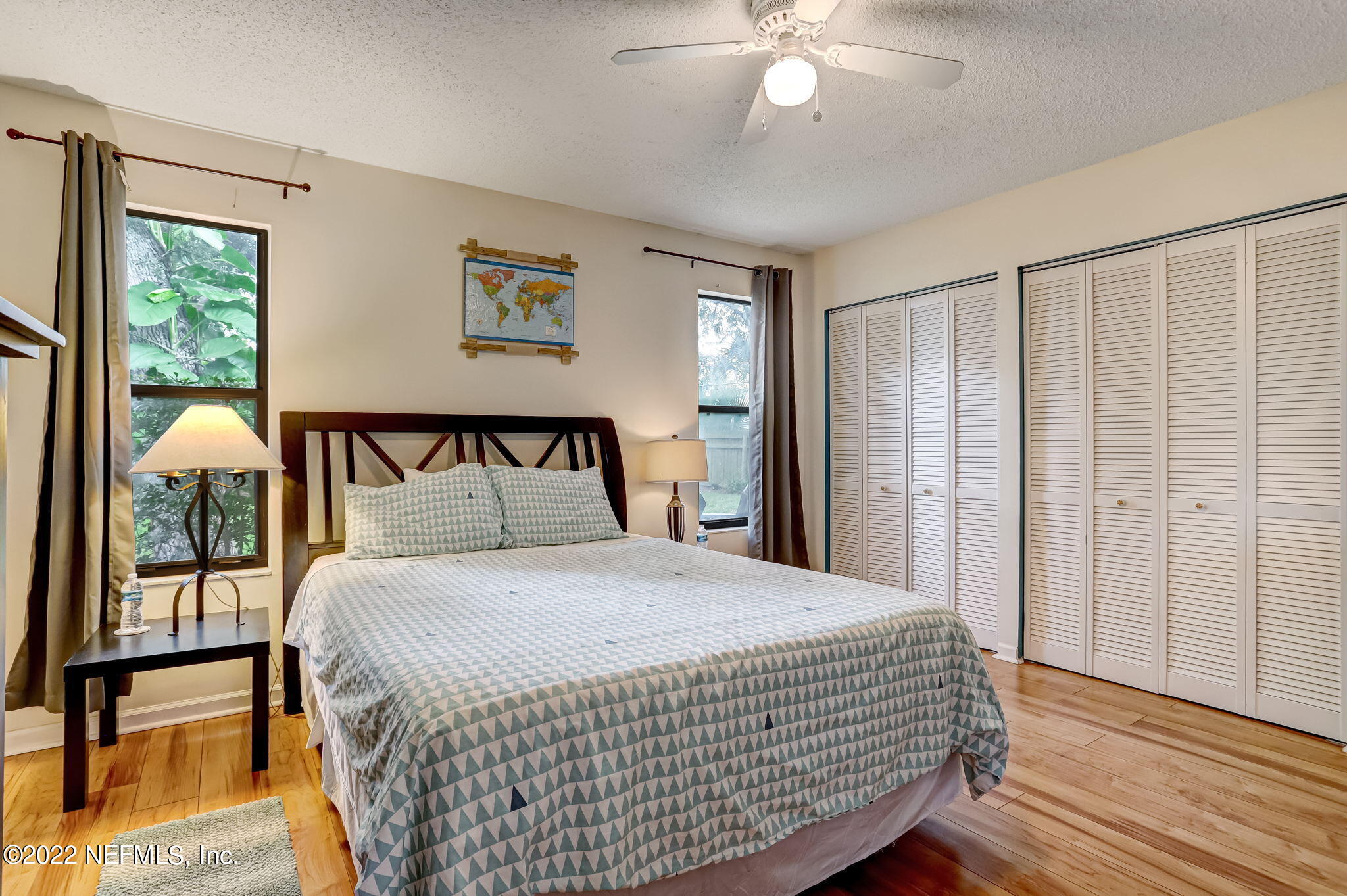 1756 Riley Street Jacksonville Beach, FL 32250 - Photo 20 of 44 a bedroom with a large bed and a chandelier