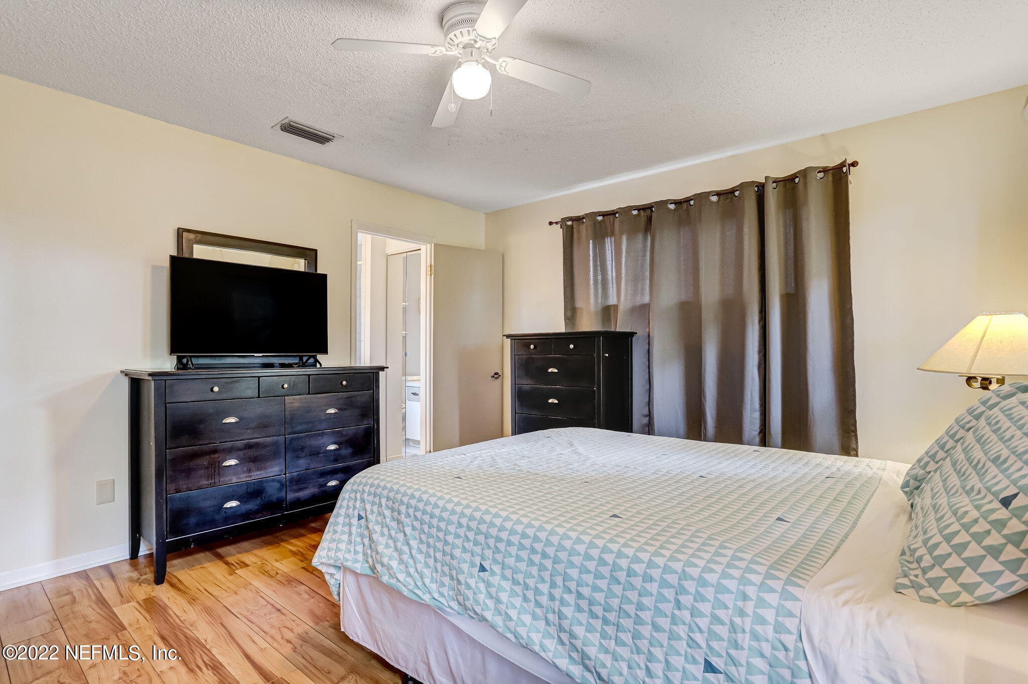 1756 Riley Street Jacksonville Beach, FL 32250 - Photo 23 of 44 a bedroom with a bed and a flat tv screen on dresser