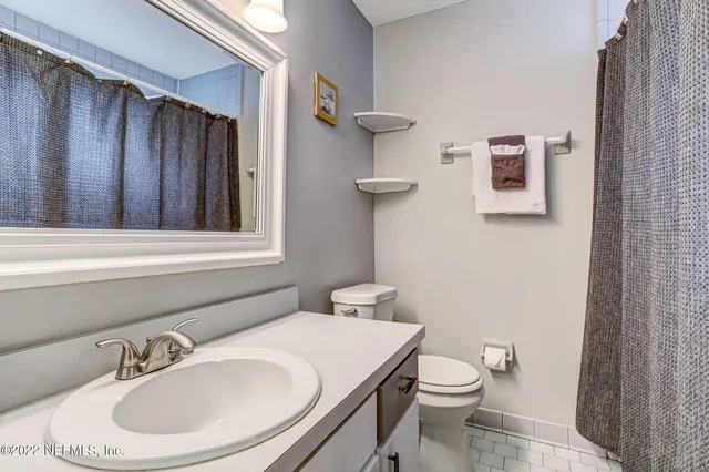 a bathroom with a sink a toilet and mirror