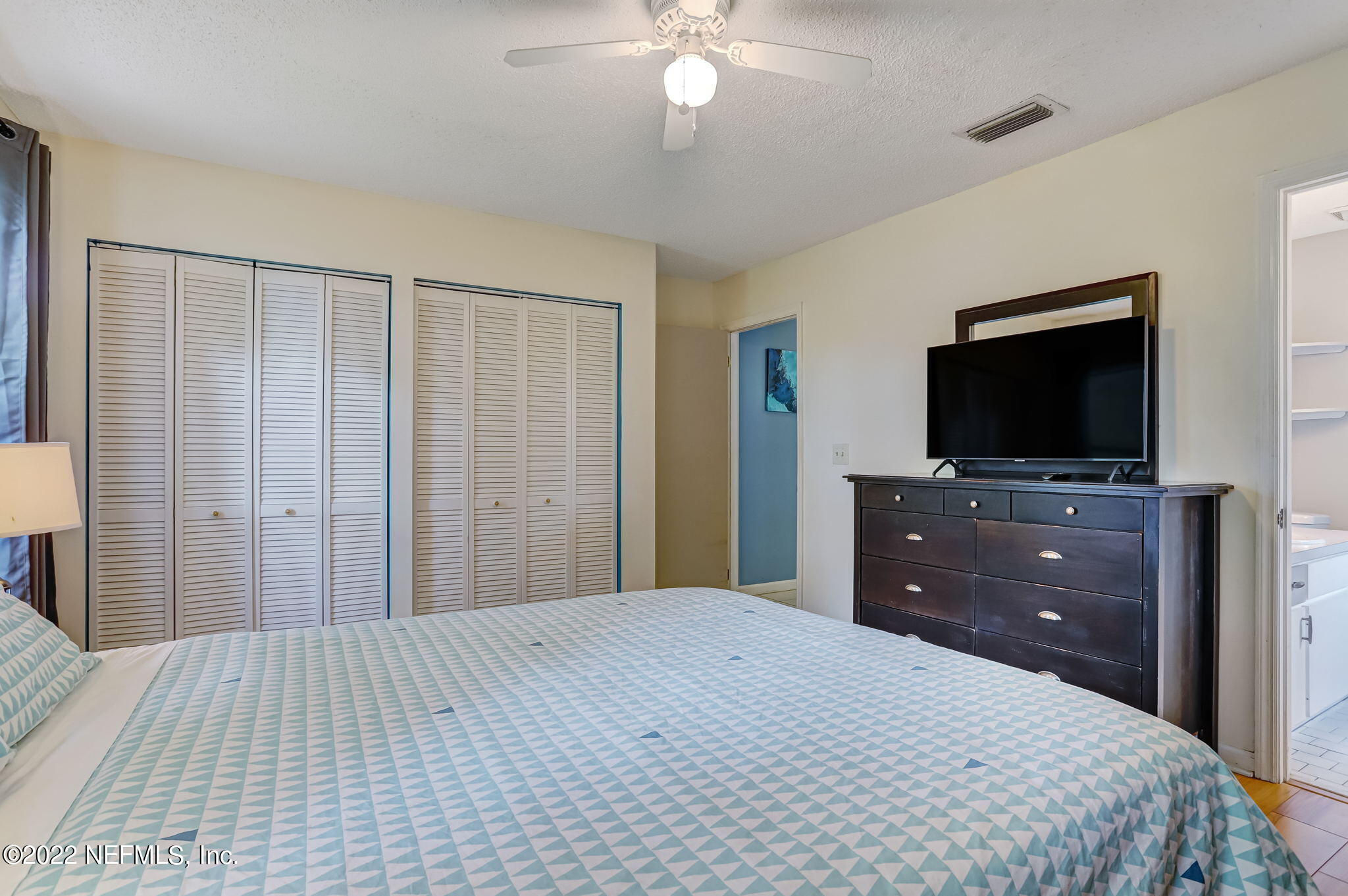 1756 Riley Street Jacksonville Beach, FL 32250 - Photo 30 of 44 a bedroom with a bed and a flat screen tv