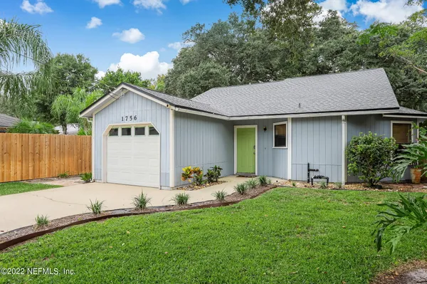a front view of a house with a garden and yard