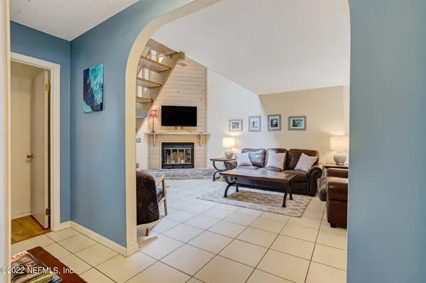 a living room with furniture a fireplace and a flat screen tv