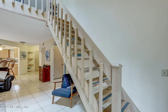a view of staircase with lots of frames on wall and a rug