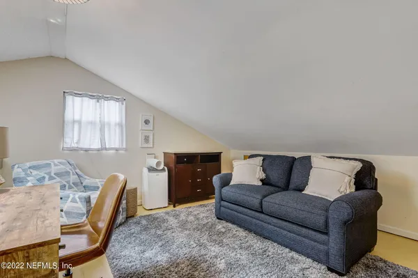 a living room with furniture and a dining table with rug