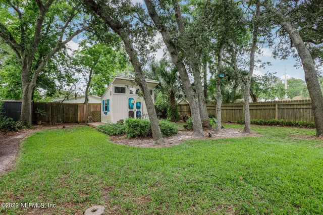a view of a house with backyard and a tree