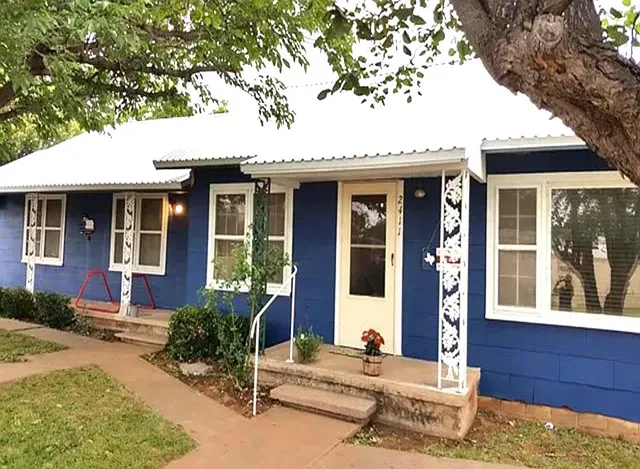 a front view of a house with a tree