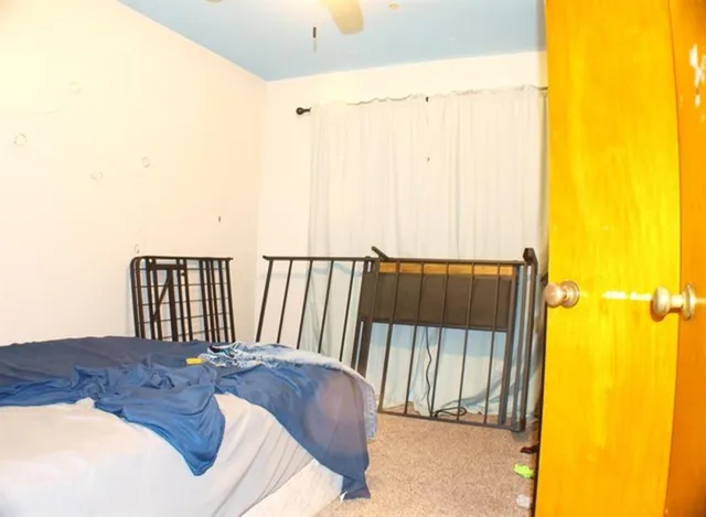 a bed sitting in a bedroom next to a window