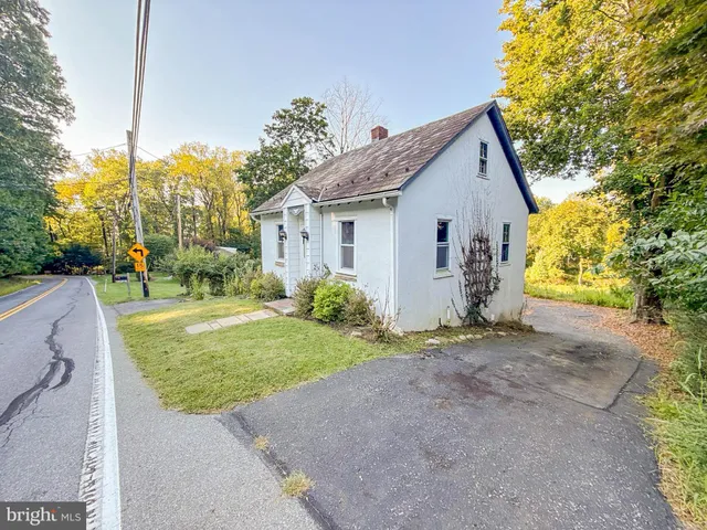 a view of a house with a yard and potted plants