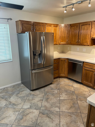 101 1501 Monroe, Unit 101 Ogden, UT 84404 - Photo 6 of 24 Kitchen with light countertops, stainless steel appliances, wood finish cabinets, and rail lighting