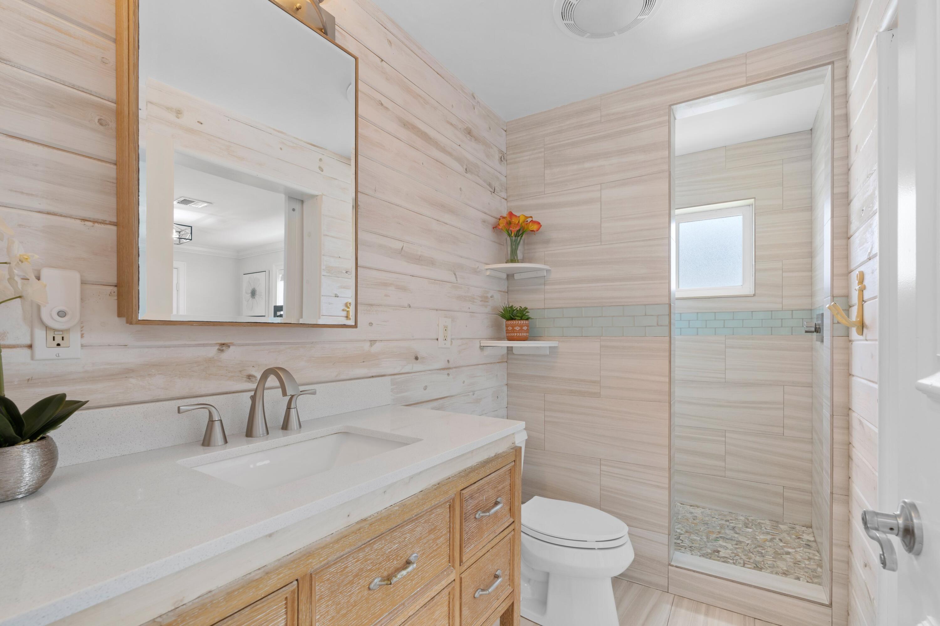 398 Southwest 13th Place Boca Raton, FL 33432 - Photo 13 of 36 a bathroom with a sink a toilet and a mirror