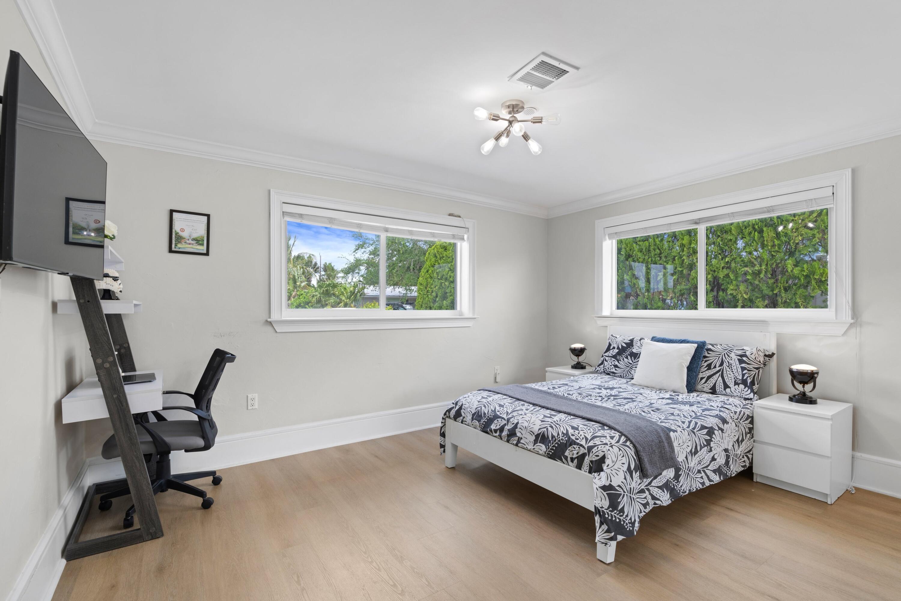 398 Southwest 13th Place Boca Raton, FL 33432 - Photo 15 of 36 a bedroom with a bed a desk and chair