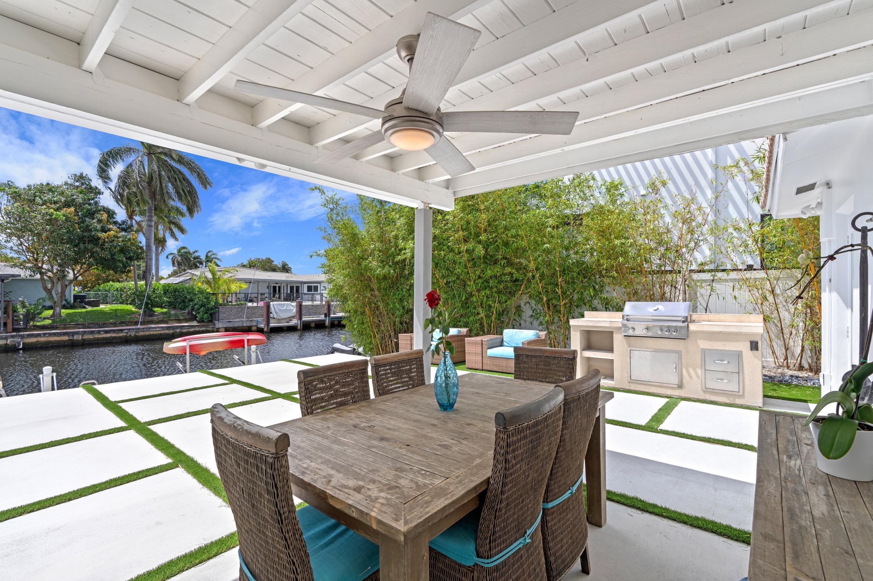 398 Southwest 13th Place Boca Raton, FL 33432 - Photo 19 of 36 a view of a patio with a dining table and chairs with a floor to ceiling window