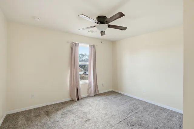 an empty room with closet and windows
