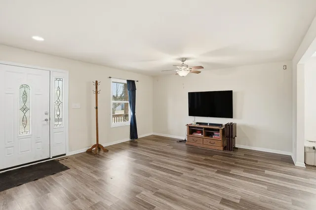 an empty room with wooden floor and windows