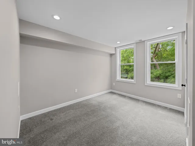 an empty room with windows and closet