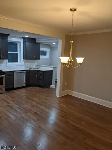 a kitchen with stainless steel appliances granite countertop a cabinets a sink and a wooden floor