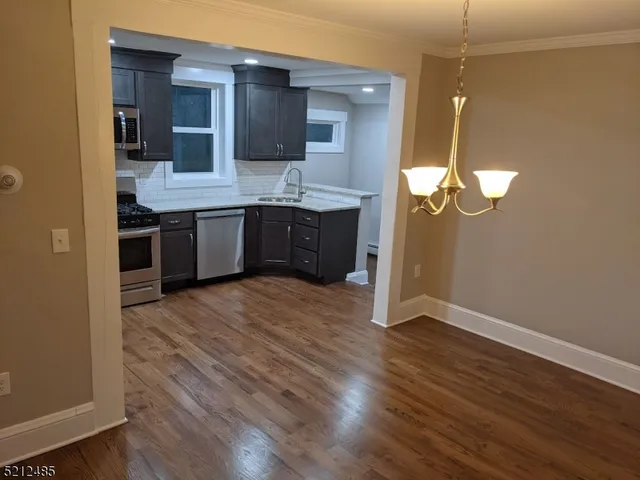 a kitchen with stainless steel appliances granite countertop a sink and wooden floor