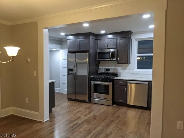 a kitchen with stainless steel appliances granite countertop a refrigerator a sink a stove and oven