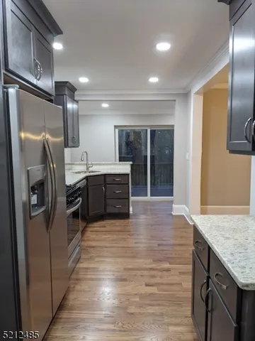 a kitchen with stainless steel appliances granite countertop a refrigerator and a sink