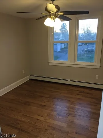 a view of a room with wooden floor and fan