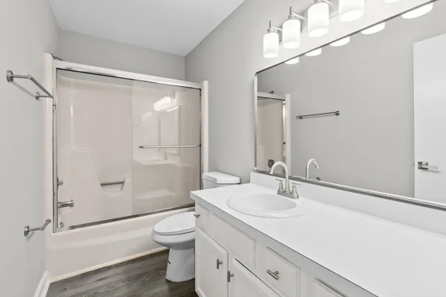 a bathroom with a sink a toilet and shower