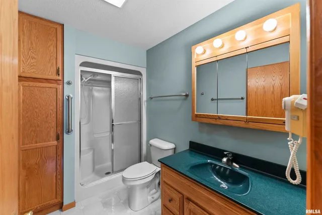 a bathroom with a granite countertop sink toilet and shower