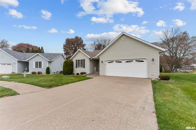 a view of a white house with a yard and large tree