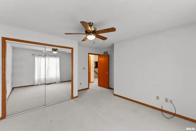 an empty room with fan and windows