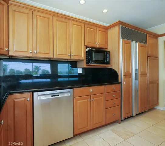 a kitchen with granite countertop white cabinets and stainless steel appliances