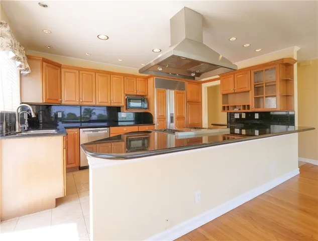 a kitchen with stainless steel appliances granite countertop a sink a stove and a refrigerator