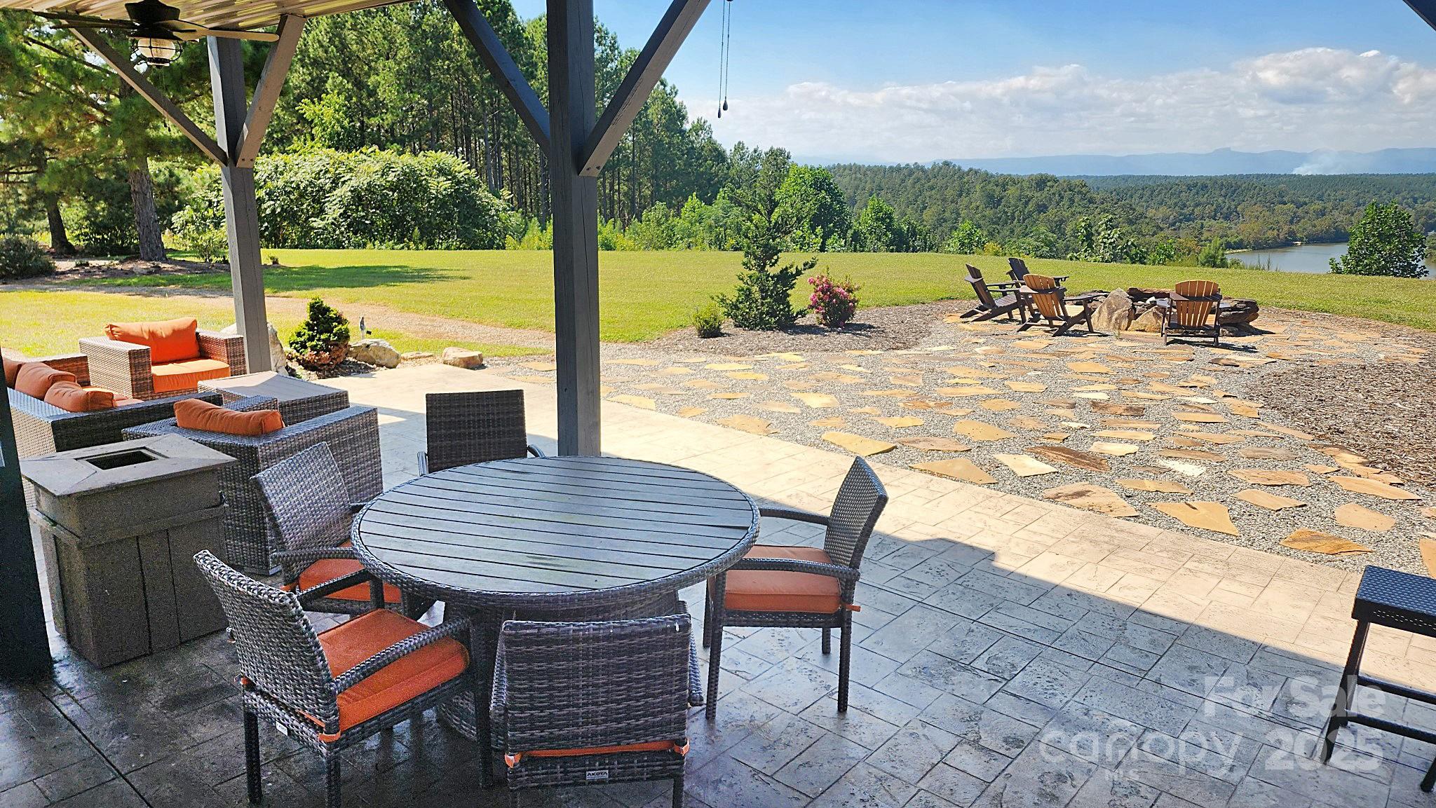 335 Table Rock Trace Northwest, Unit 154 Valdese, NC 28690 - Photo 25 of 25 a view of a roof deck with couches under an umbrella next to a yard