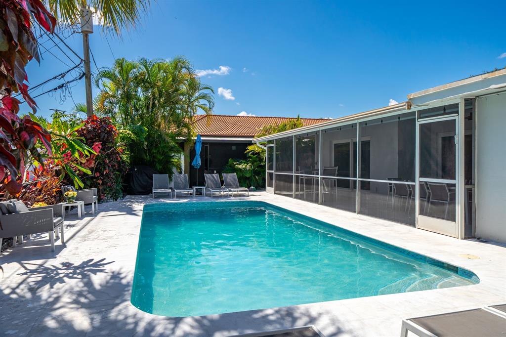 a swimming pool with outdoor seating and yard