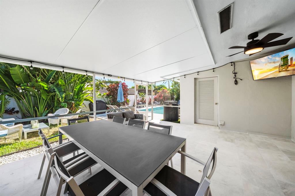 4804-4806 Northeast 21st Avenue Fort Lauderdale, FL 33308 - Photo 14 of 31 a view of a patio with table and chairs potted plants with floor to ceiling window