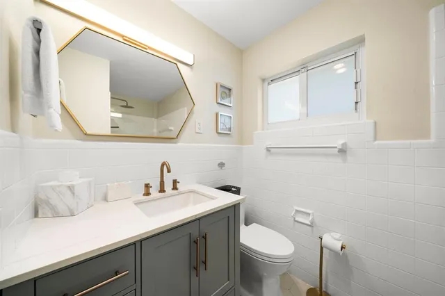 a bathroom with a toilet a sink and mirror