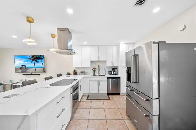 a kitchen with a sink stainless steel appliances and refrigerator