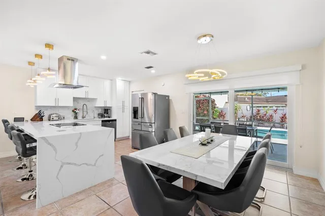 a kitchen with stainless steel appliances a table chairs and a refrigerator