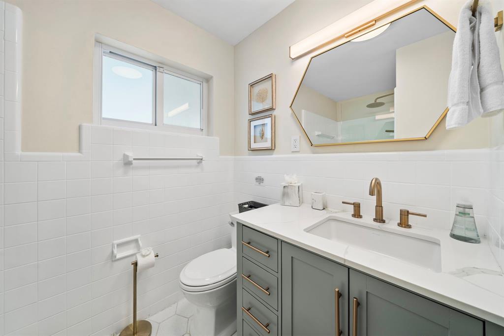 4804-4806 Northeast 21st Avenue Fort Lauderdale, FL 33308 - Photo 5 of 31 a bathroom with a toilet a sink a vanity and mirror
