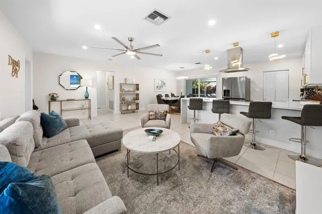 a living room with lots of furniture and view of kitchen